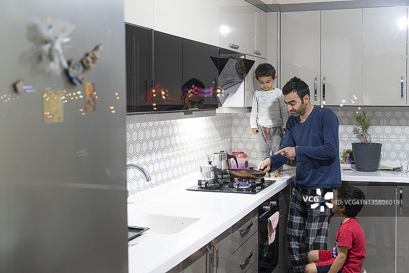 爸爸为孩子们在炉子上做饭图片素材