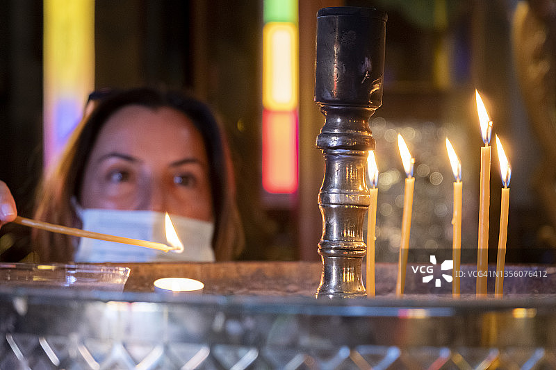 女子在东正教教堂点燃蜡烛图片素材