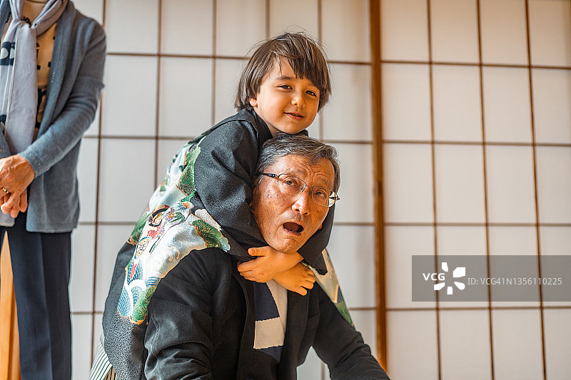 穿着日式和服与祖父玩耍的欧亚小男孩图片素材