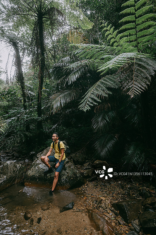 男人在冲绳雨林徒步旅行中休息，日本图片素材