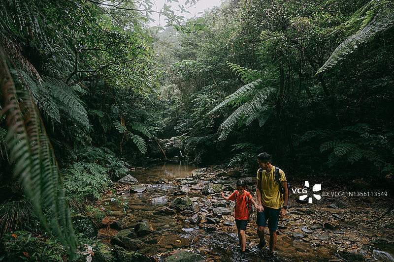 父亲和孩子在冲绳丛林徒步旅行，中国日本图片素材