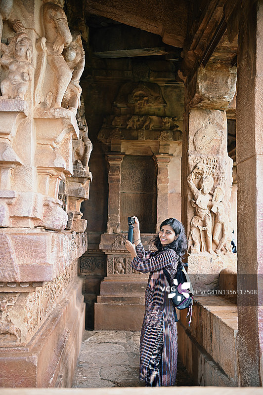在古印度石雕寺庙中摄影的女人，帕塔达卡尔，卡纳塔克邦图片素材
