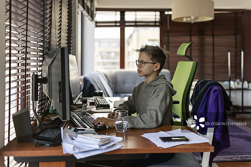 青少年男孩在家使用台式电脑图片素材