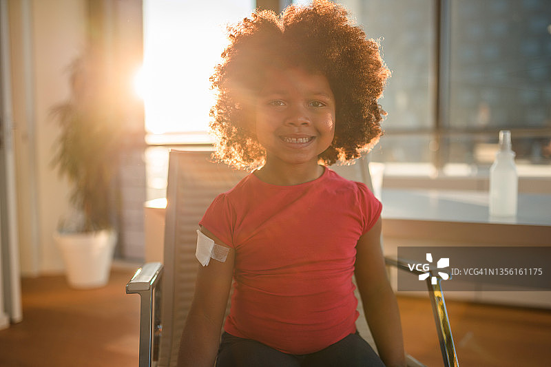 接种新冠疫苗后在医生办公室的非裔美国女孩图片素材