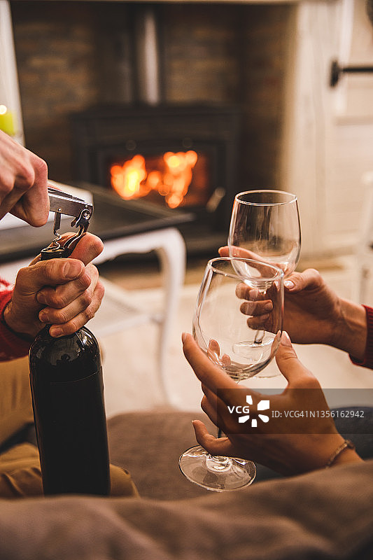 情侣在舒适的壁炉旁享用红酒图片素材