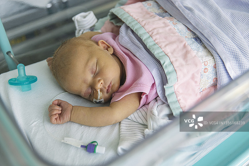 患有新生儿黄疸的新生女婴躺在医院的婴儿床上图片素材