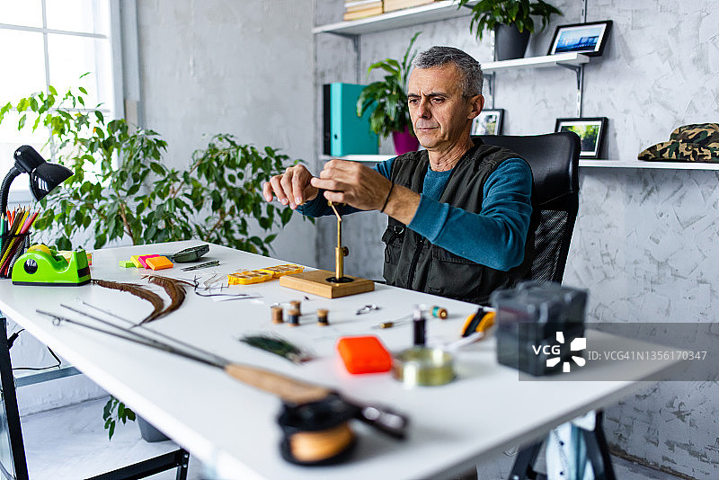 中年男人为他的小生意制作钓鱼用具图片素材