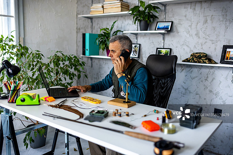 小型企业主在车间使用笔记本电脑与客户交谈图片素材