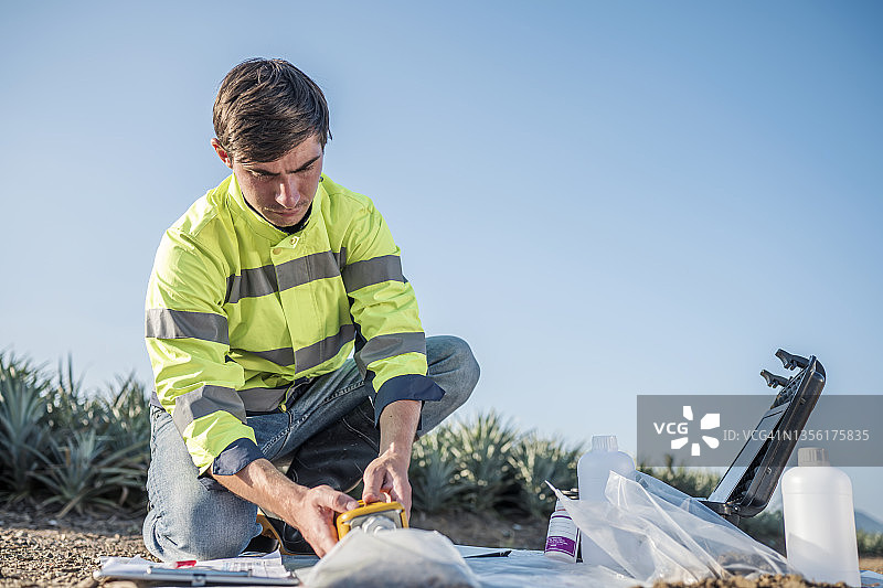 测量土壤微生物群落样本。生物学家取土样并使用千分尺测量土壤肥力，以种植菠萝。图片素材