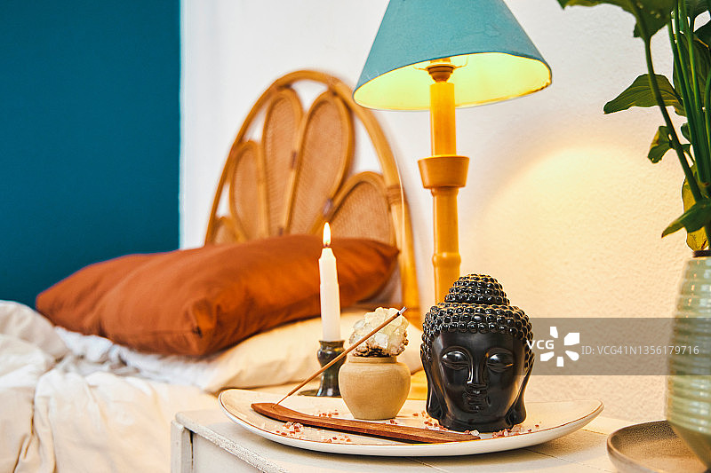 白天空荡卧室里的佛像摆件、香和蜡烛图片素材