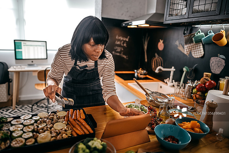女人观看平板电脑上的食谱图片素材