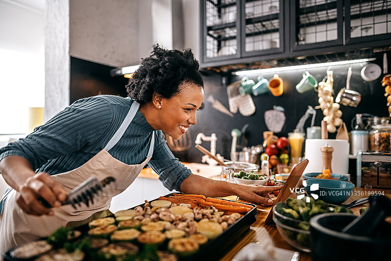 女人观看平板电脑上的食谱图片素材