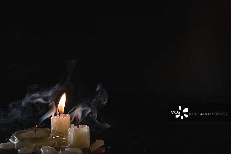 深色背景上的几支蜡烛，带有神秘烟雾图片素材