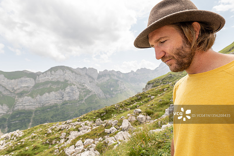 戴帽子的年轻人在瑞士阿尔卑斯山徒步旅行图片素材