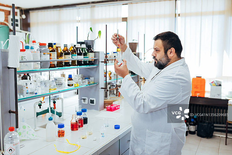 在现代实验室里做实验的专注的化学家图片素材