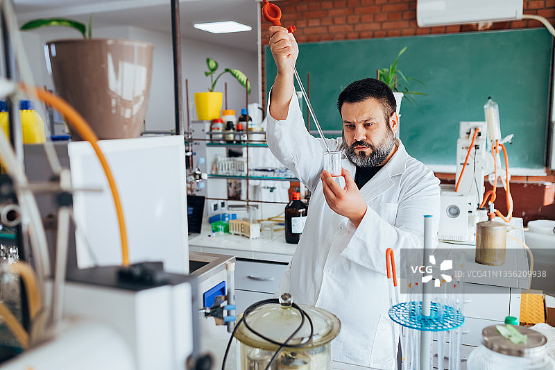 科学家用移液管稀释实验室玻璃器皿中的溶液图片素材