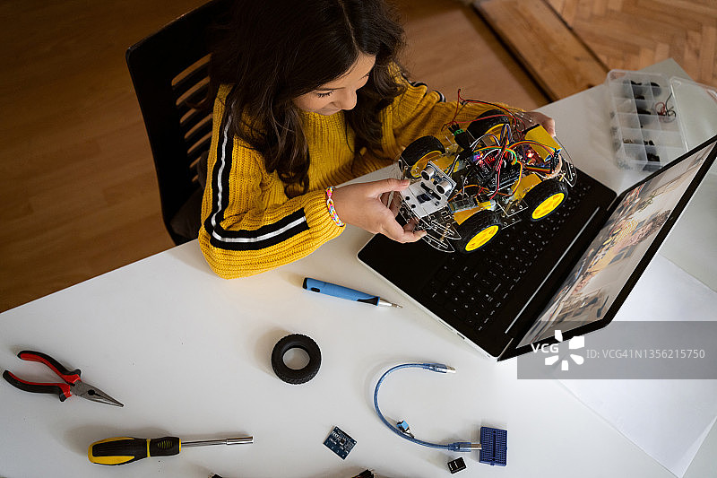 女学生在视频通话展示机器人汽车原型的俯视角度照片图片素材
