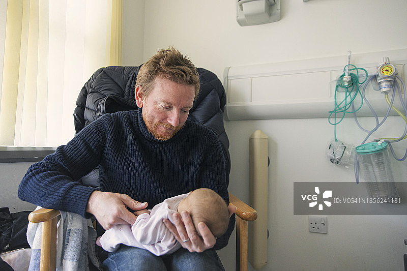 父亲慈爱地看着他的新生女婴图片素材