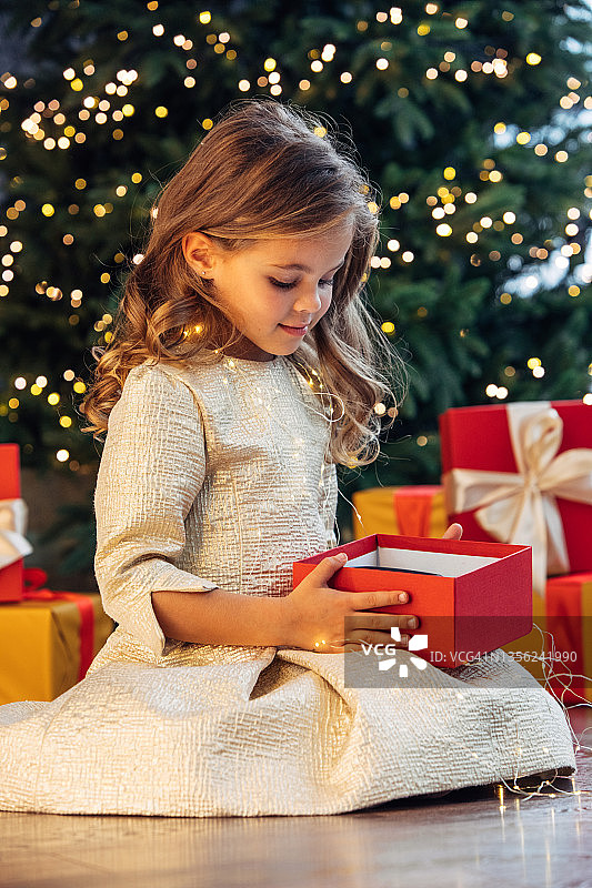 抱着圣诞礼物的可爱蓝眼睛女孩图片素材