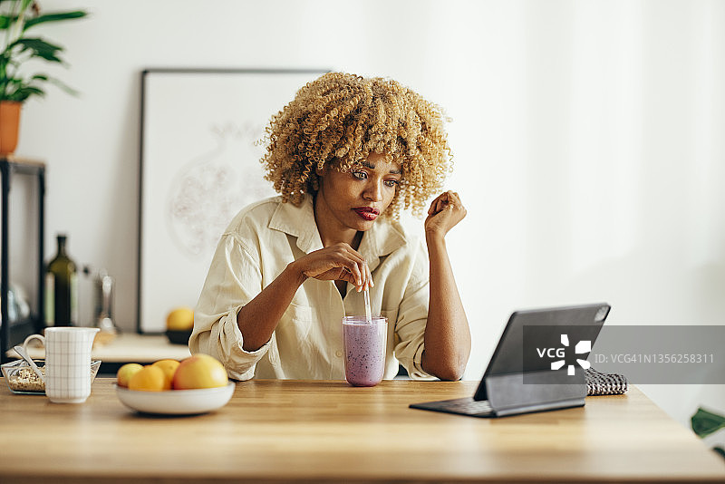 在家中使用平板电脑的严肃女人图片素材