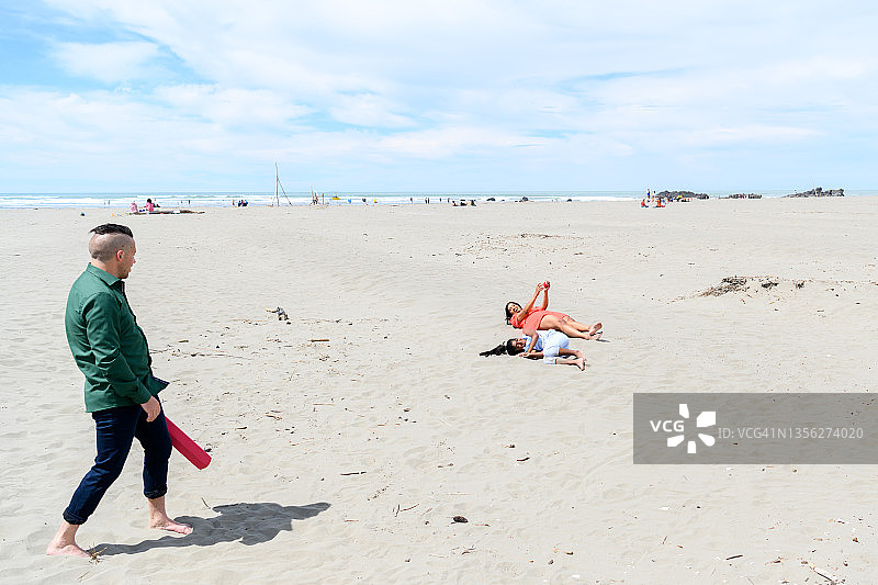 幸福的三口之家在海滩上共度美好时光图片素材