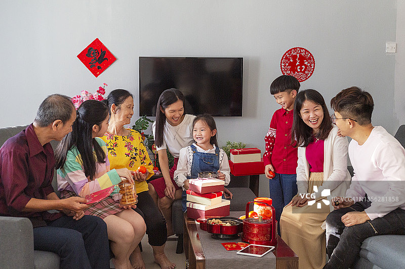中国新年期间的多代同堂家庭聚会，坐在客厅的沙发上图片素材