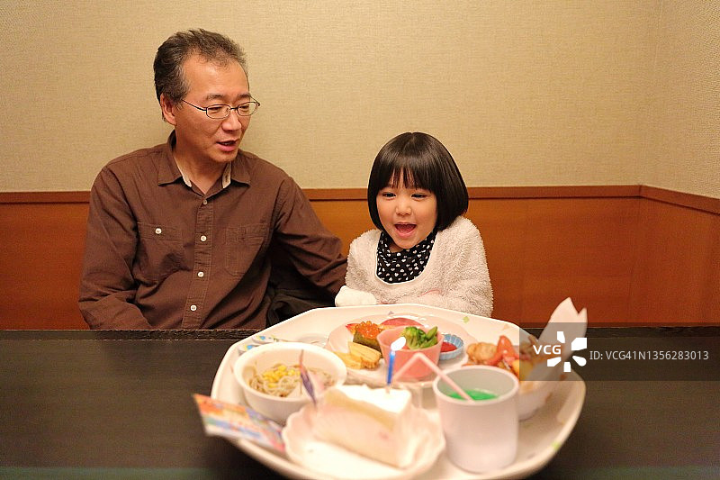 父亲和孩子分享生日美食图片素材