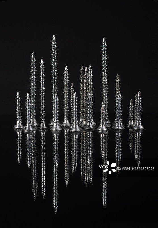 螺丝钉的夜间城市：黑色背景上的反光螺丝钉图片素材