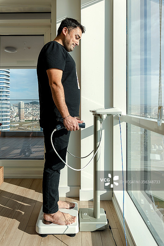 男人使用体重秤图片素材