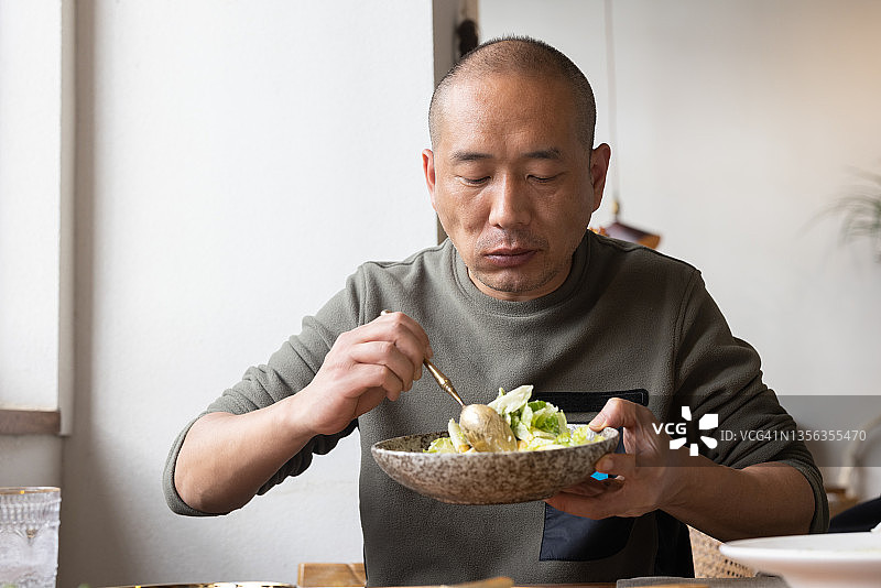 在餐厅吃沙拉的亚洲男人图片素材