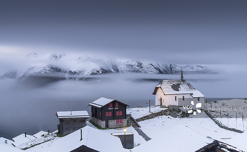瑞士被白雪覆盖的高山村庄上空的雾气图片素材