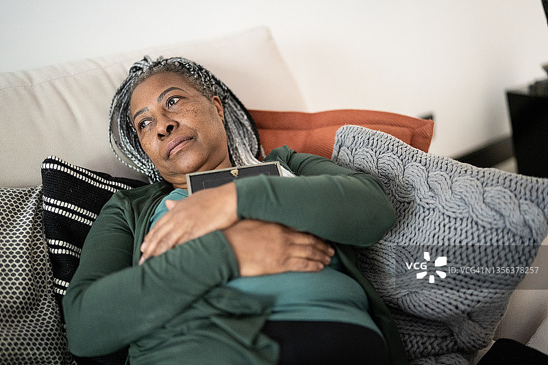 拿着相框思念家人的年长女人图片素材