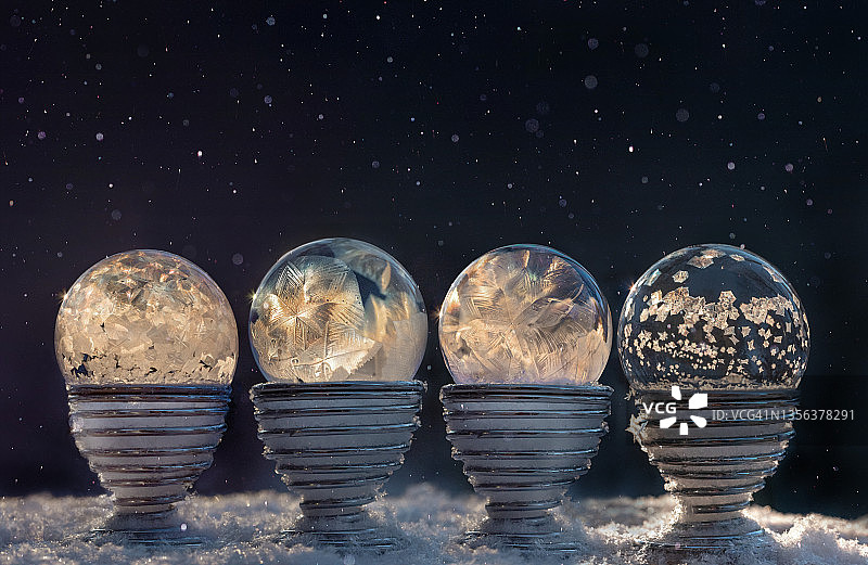 夜晚金属蛋杯上四个冰冻的肥皂泡图片素材