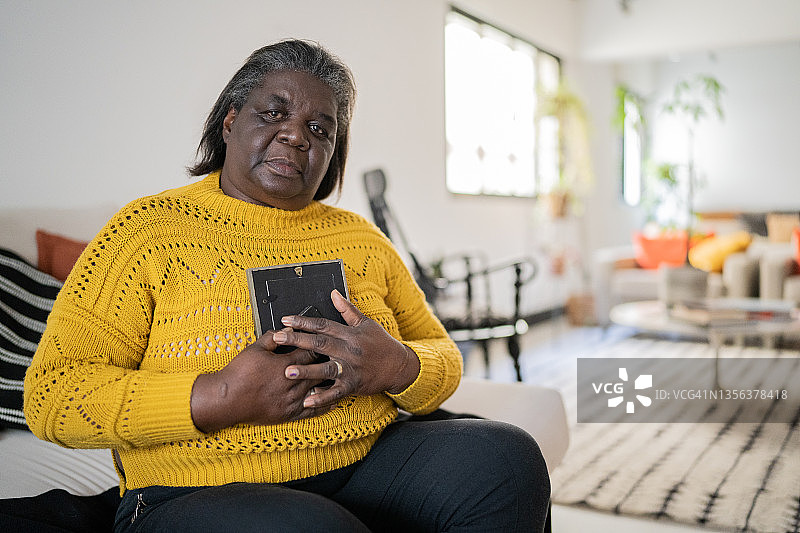 手持照片思念家人的年长女人 портрет图片素材