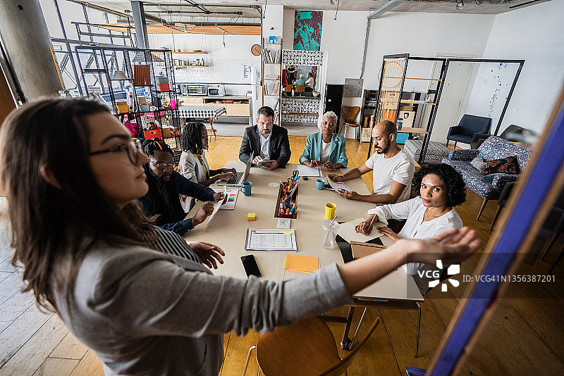 女人在联合办公室内为同事做商务演示图片素材