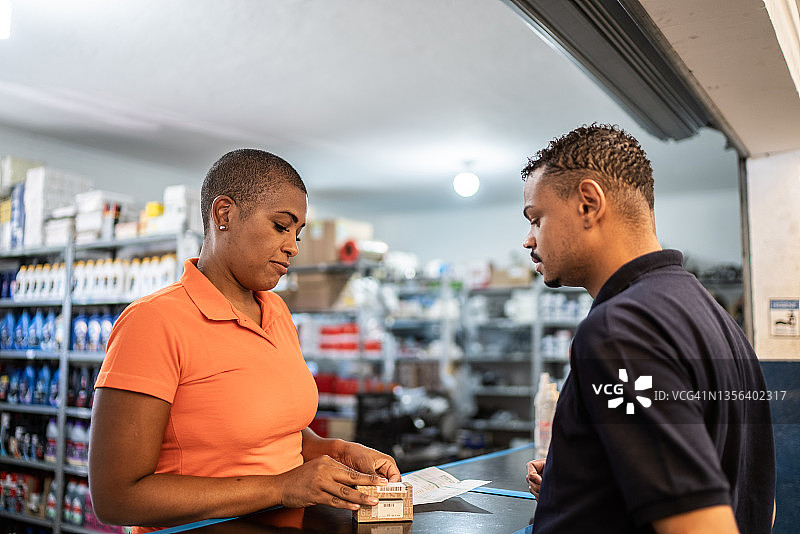 顾客在汽车修理店与女销售员交谈图片素材