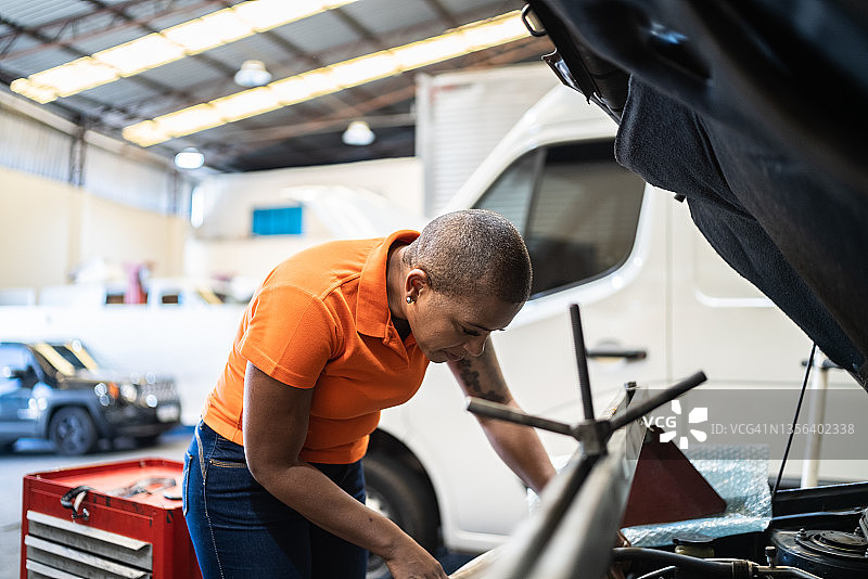 在汽车修理店里修车的女人图片素材