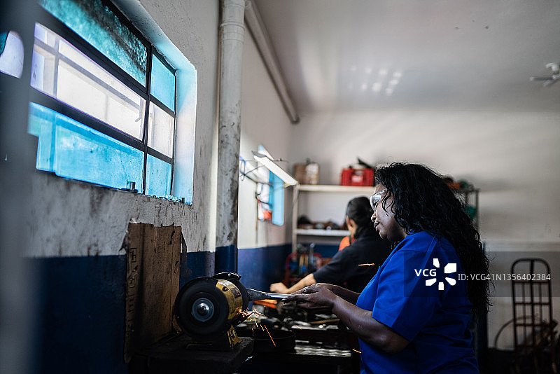 在汽车修理店里修车的女人图片素材