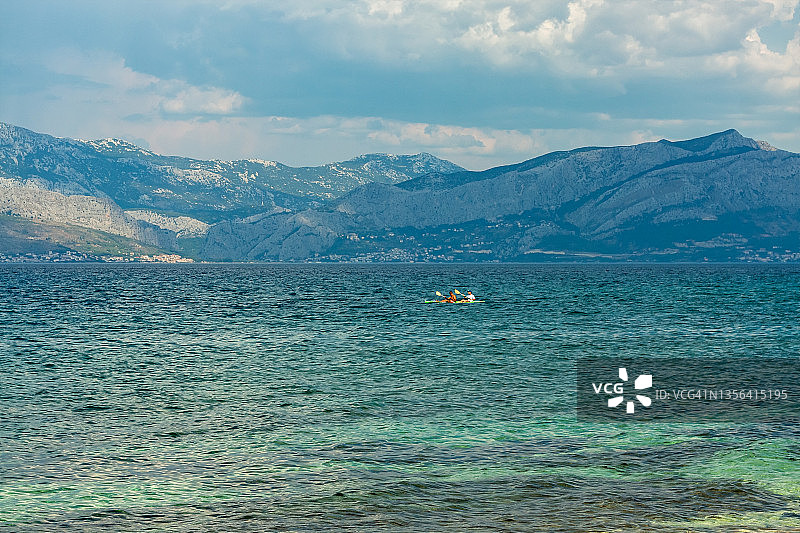 乘坐皮划艇经过布拉奇岛亚得里亚海海岸的游客图片素材