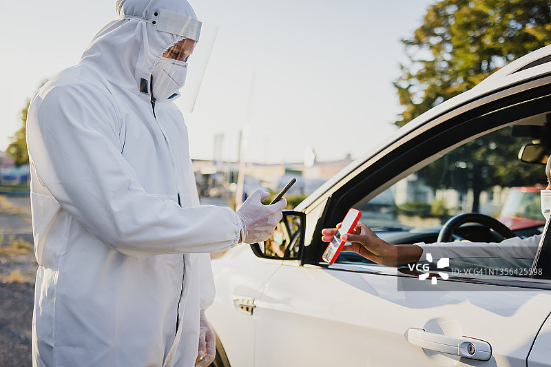 身穿防护服的医护人员扫描有效的新冠疫苗电子证书图片素材
