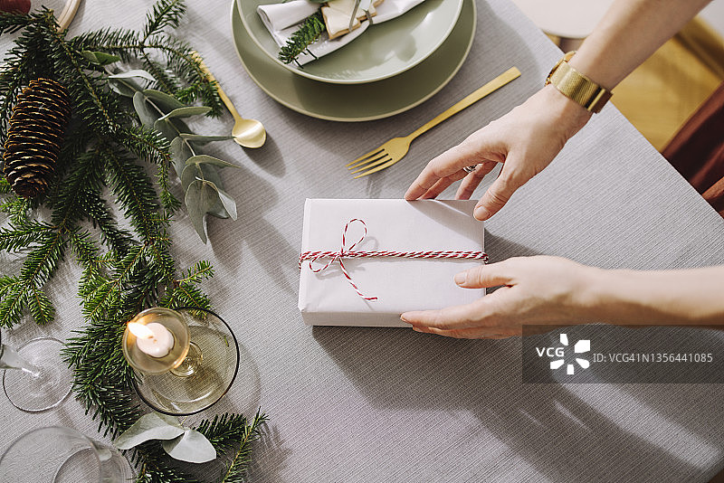 新年除夕准备：一位匿名女性在布置圣诞晚餐桌图片素材