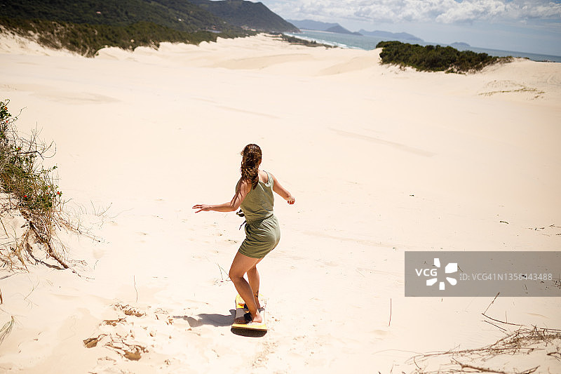 玩滑沙板的女人图片素材