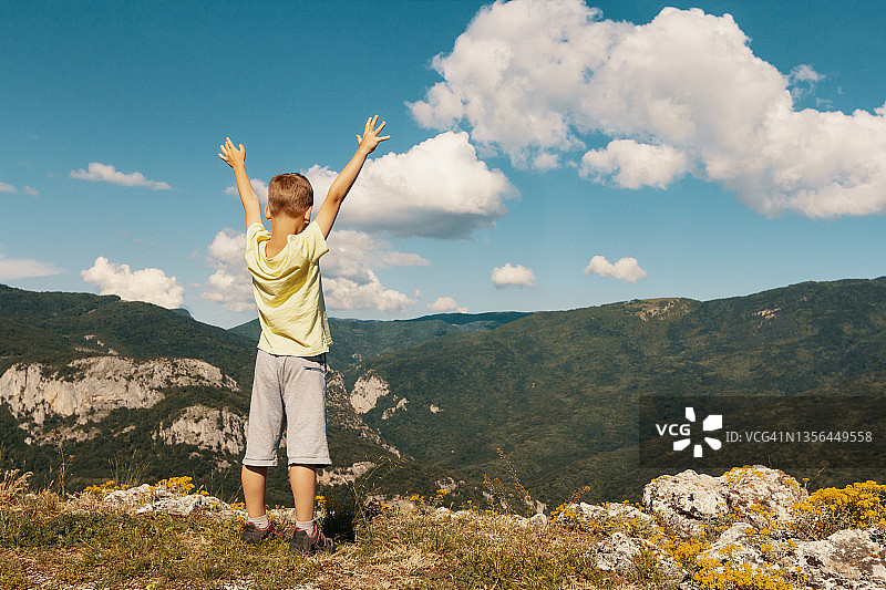 儿童登顶成功后欣赏山景图片素材