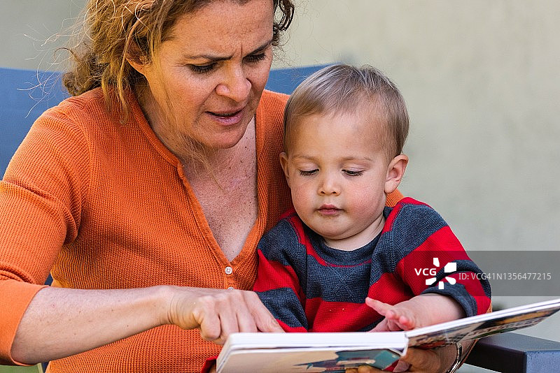 真实生活：日托中心保育员给男童读书图片素材