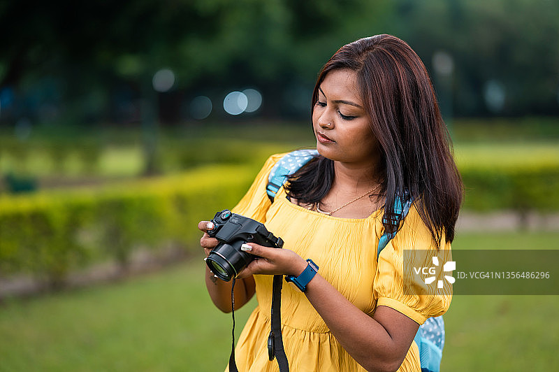 手持相机观看照片的年轻女孩图片素材
