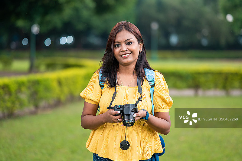 手持单反相机的印度女摄影师图片素材