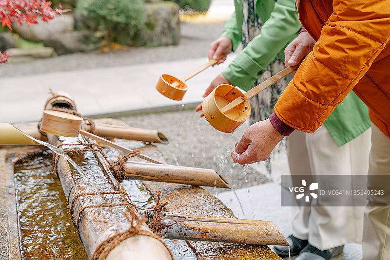 一对年长的夫妇在日本寺庙清洁双手图片素材