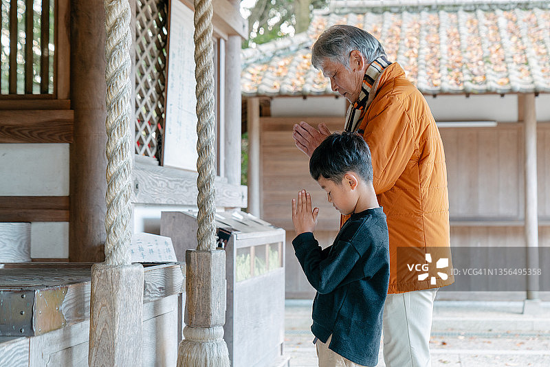爷爷和孙子在日本寺庙祈祷图片素材