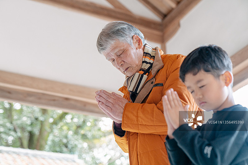 爷爷和孙子在日本寺庙祈祷图片素材