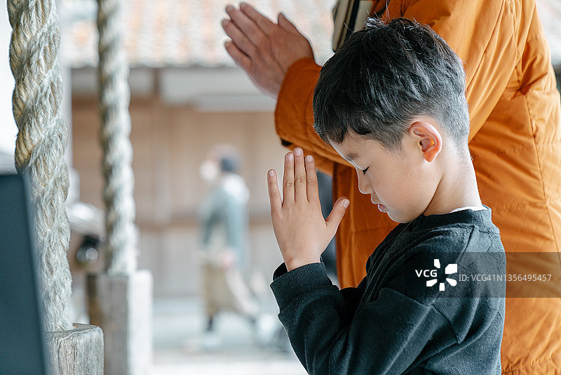 男孩和祖父在日本寺庙祈祷图片素材